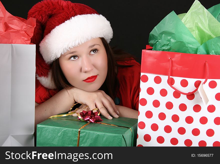 Beautiful caucasian brunette dreaming about christmas amongst gifts. Beautiful caucasian brunette dreaming about christmas amongst gifts