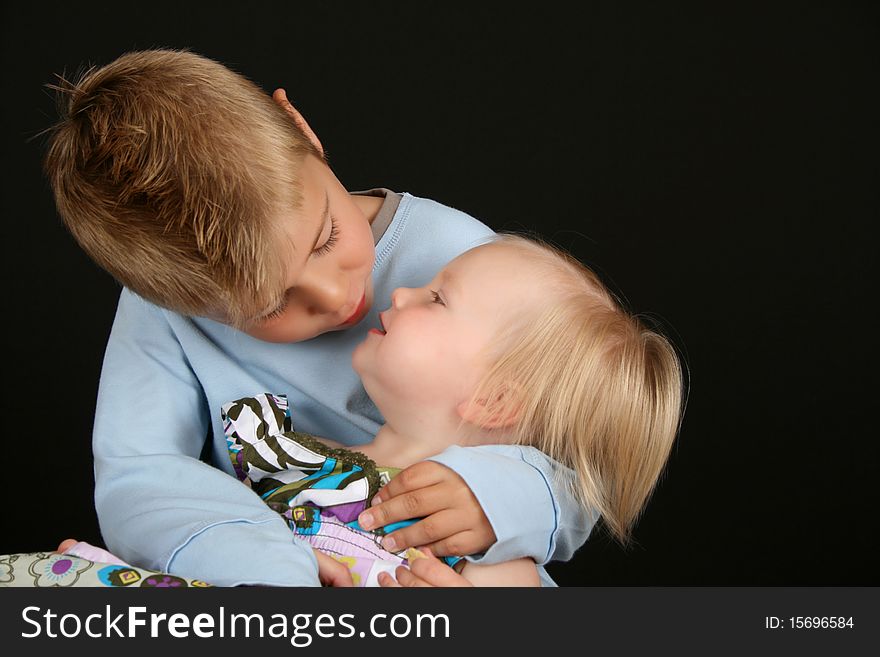 Cute brother holding his toddler sister in his arms. Cute brother holding his toddler sister in his arms