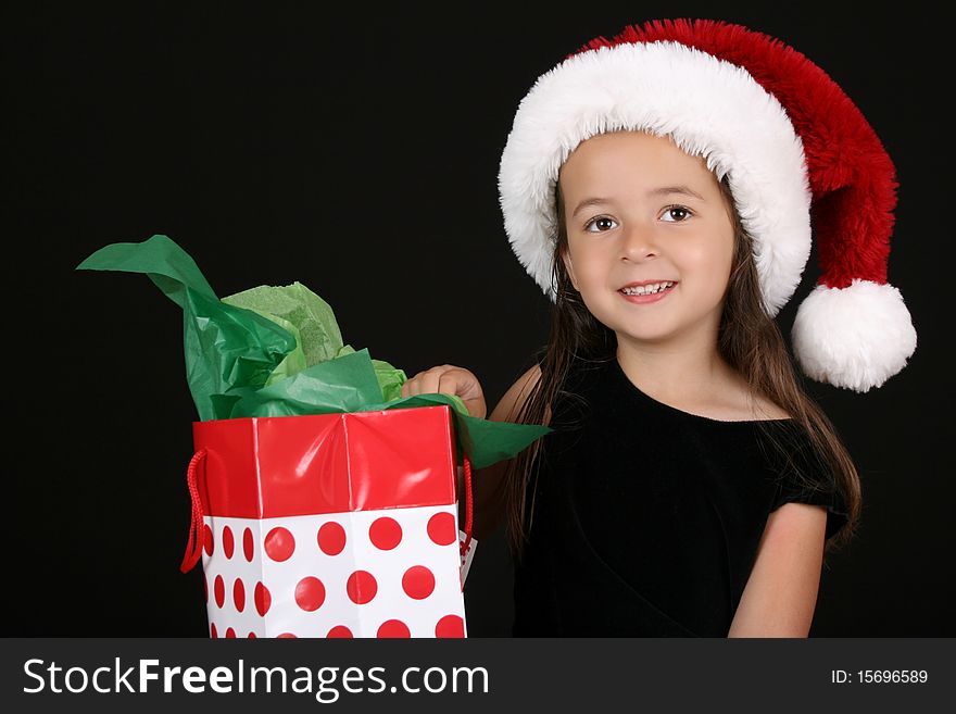 Cute little brunette girl wearing a christmas hat. Cute little brunette girl wearing a christmas hat