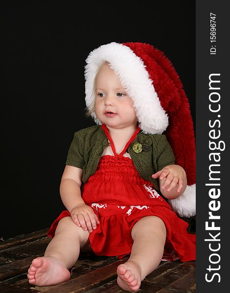 Cute blond girl wearing a red dress and christmas hat. Cute blond girl wearing a red dress and christmas hat