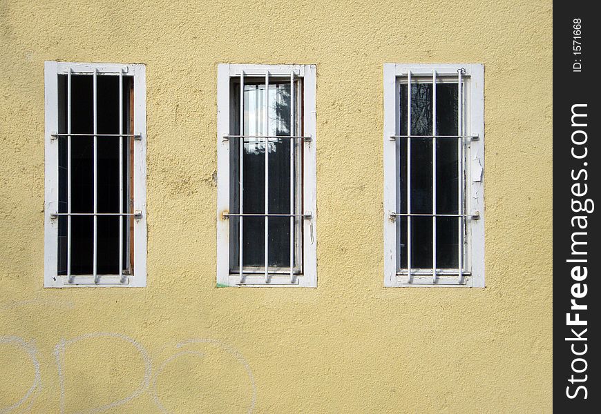 Three window with metallic shutter and yellow wall. Three window with metallic shutter and yellow wall