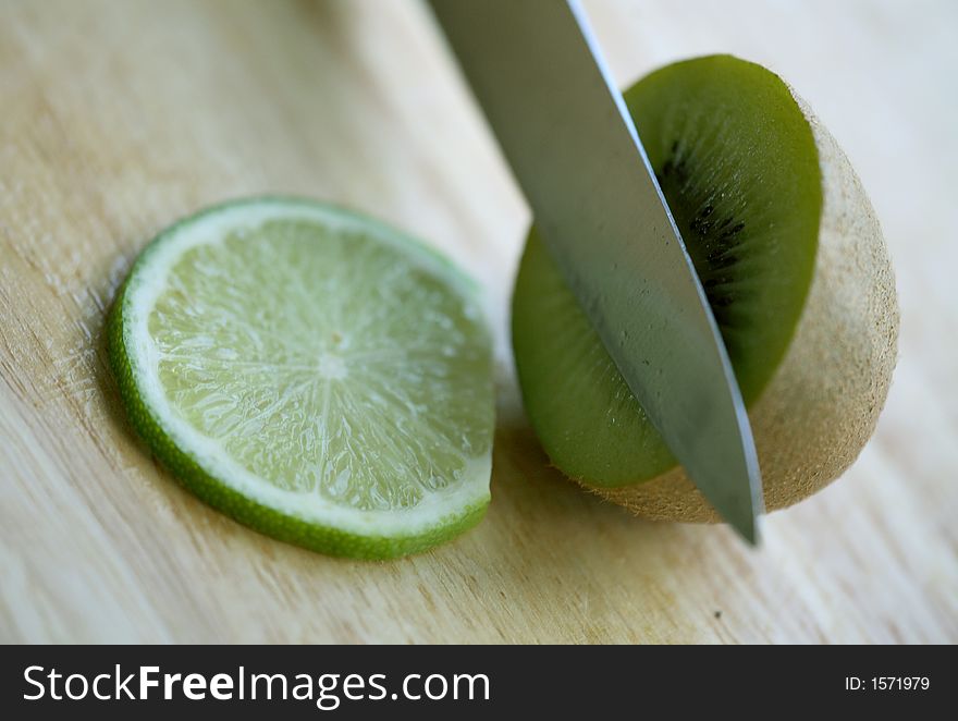 Close up of a kiwi and knife with lime slice. Close up of a kiwi and knife with lime slice