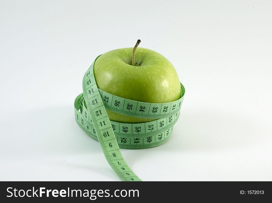 Apple surounded by a 	
metric ribbon in white background. Apple surounded by a 	
metric ribbon in white background