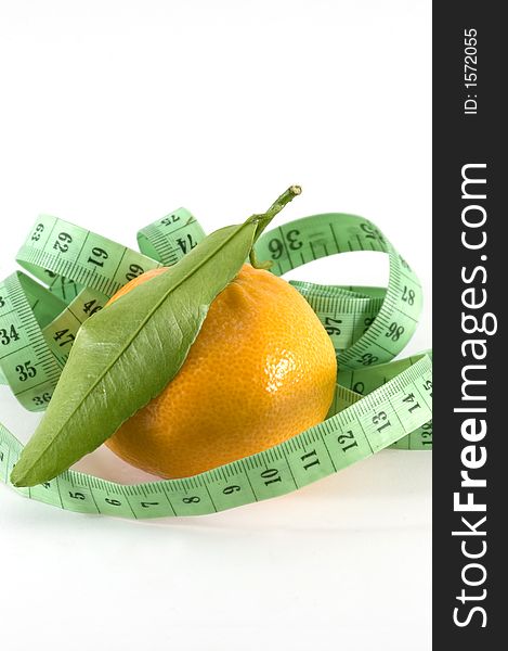 Small orange surounded by a metric ribbon in white background. Small orange surounded by a metric ribbon in white background