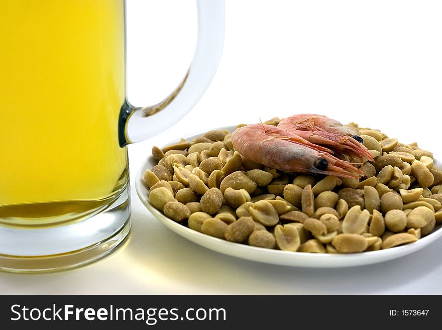 Two mugs of beer and plate with snacks.