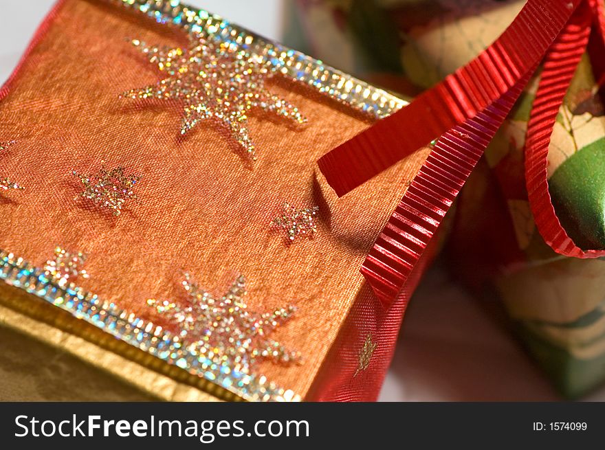 Christmas presents, gold, green and red, on white paper snowflakes. Christmas presents, gold, green and red, on white paper snowflakes.