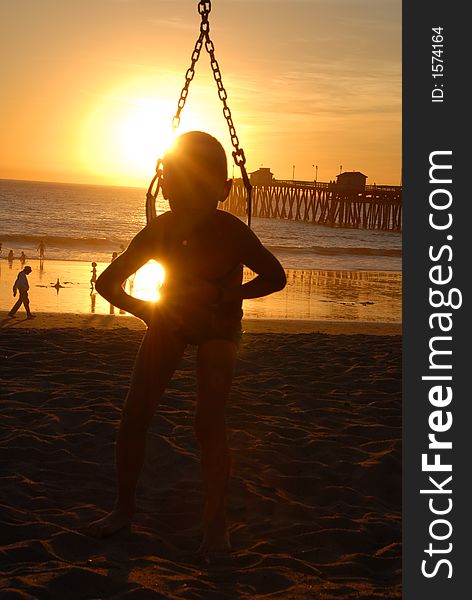 A boy on the swings on the beach