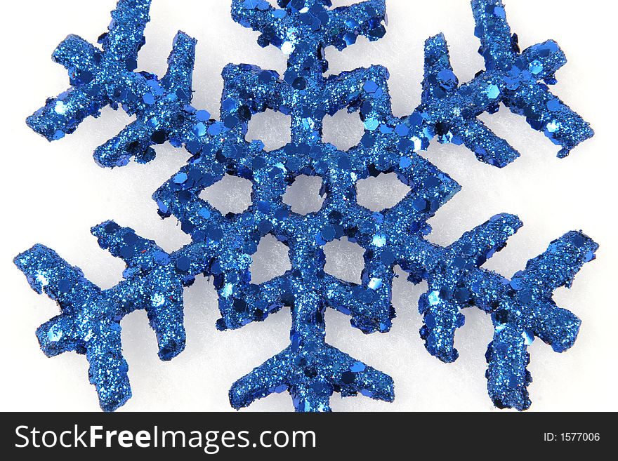 Blue Snowflake on white taken closeup. Blue Snowflake on white taken closeup