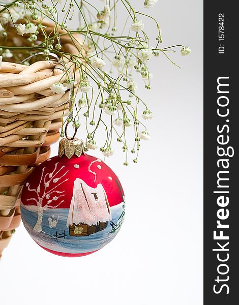 Red christmas ball, green branch and basket. With copy-space, white background. Red christmas ball, green branch and basket. With copy-space, white background