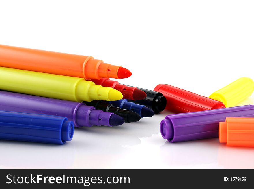 Felt pens with lids next to them on an isolated background