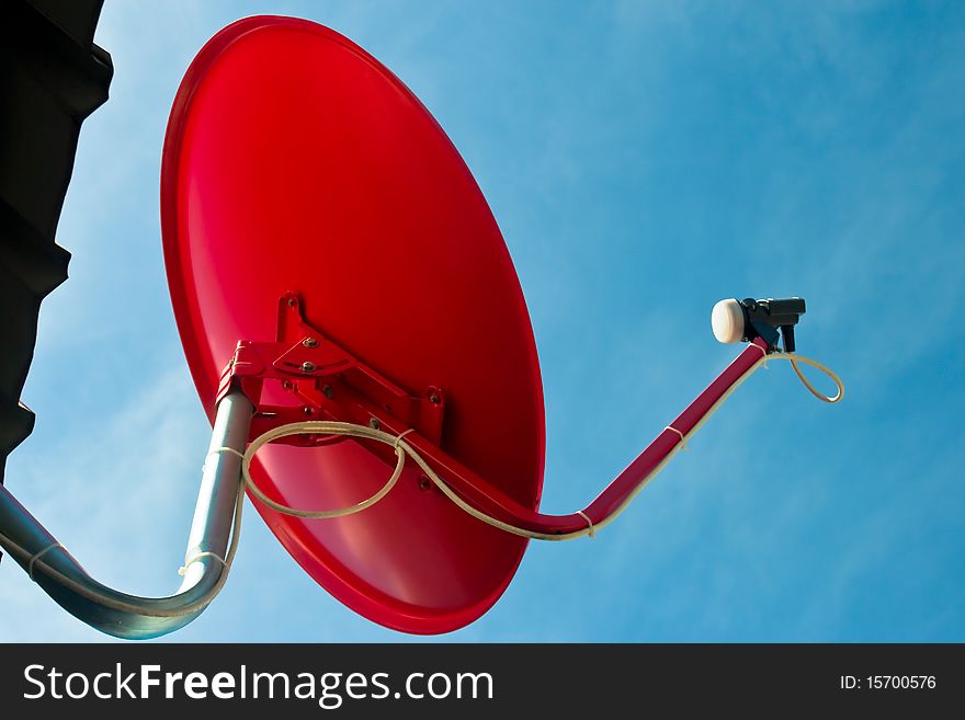 Red satellite dish with blue sky
