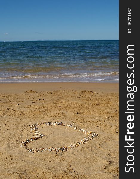 Love heart made of shells on beach background concept image. Love heart made of shells on beach background concept image