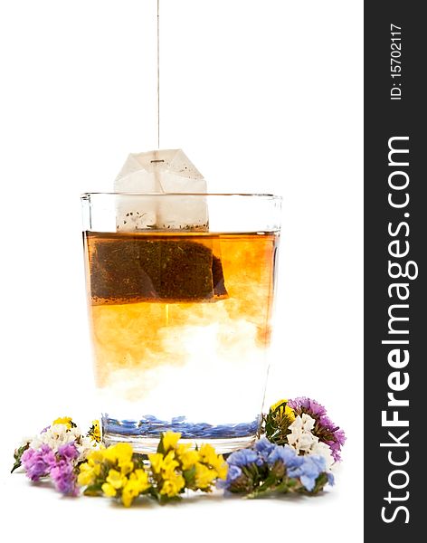 Hot tea in glass cup with flowers. Isolated on white background. Hot tea in glass cup with flowers. Isolated on white background