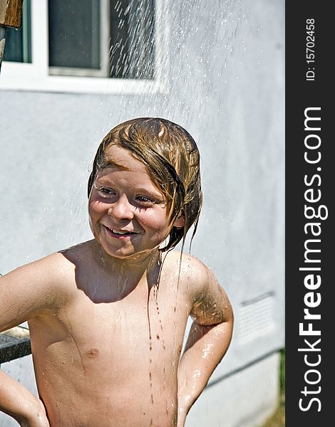 Child has a refreshing shower in the heat