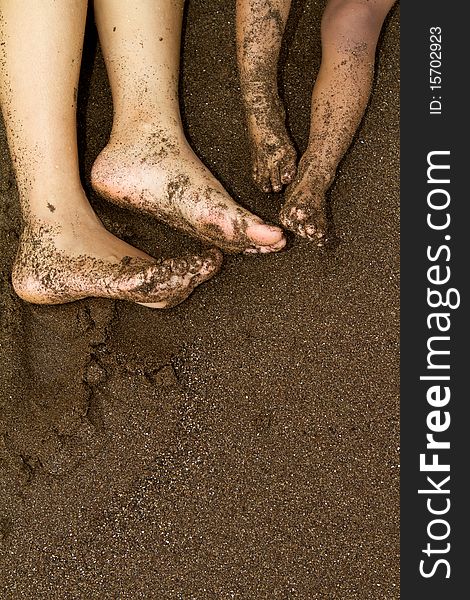 Family feet on beach sand