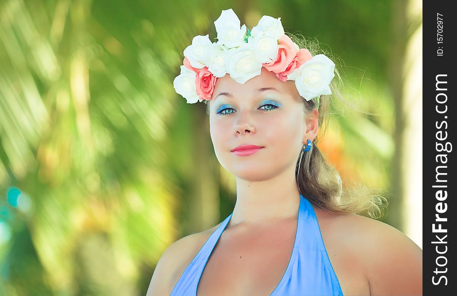 Woman in flower diadem on the beach