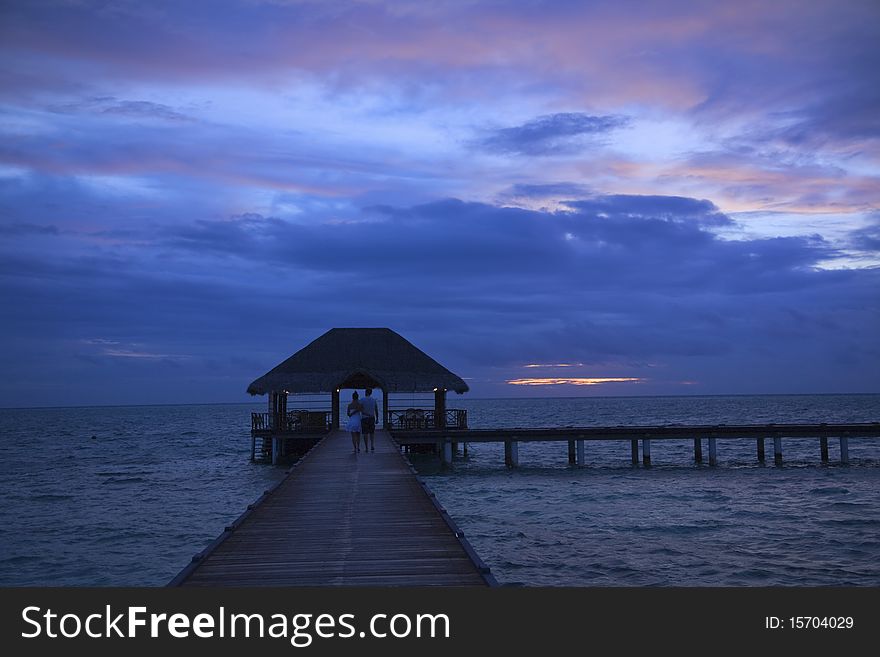 Medhufushi Island resort with water bridge  over sunset. Medhufushi Island resort with water bridge  over sunset