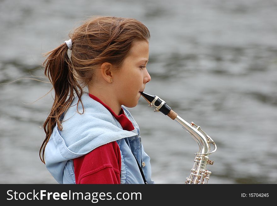 Girl with saxophone outdoor.Near Kiev,Ukraine