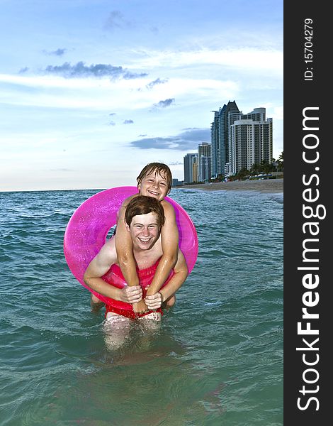 Brothers in a swim ring have fun in the ocean