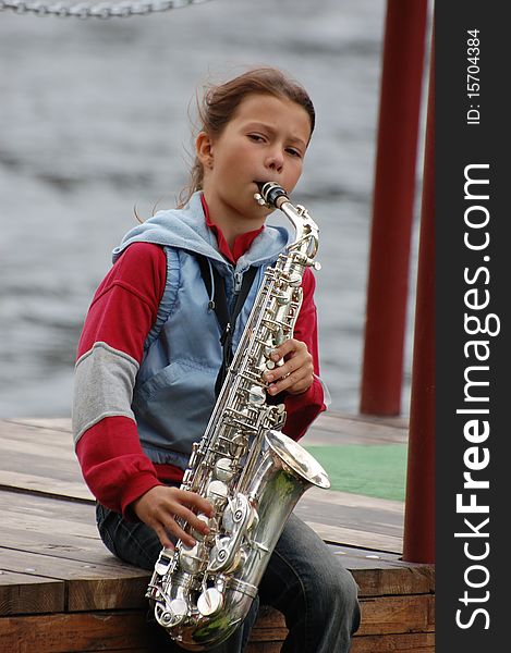 Girl with saxophone outdoor.Near Kiev,Ukraine