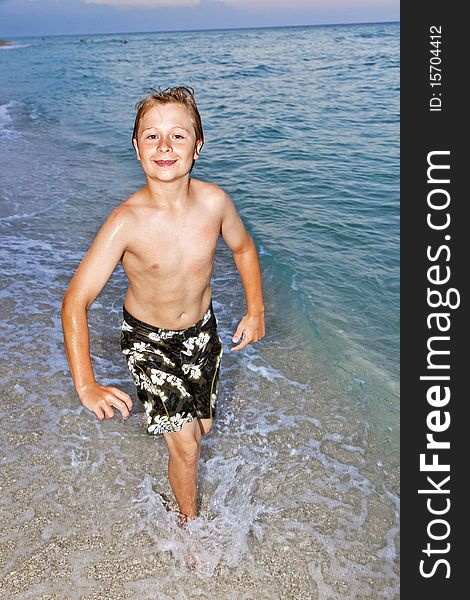 Young boy is jogging at the beautiful beach