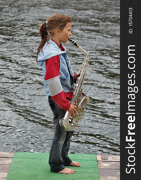 Girl with saxophone outdoor.Near Kiev,Ukraine