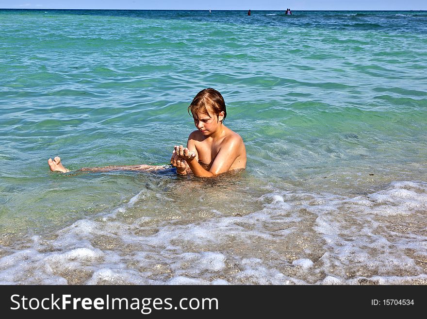 Boy Enjoys The Clear Water In The Ocean