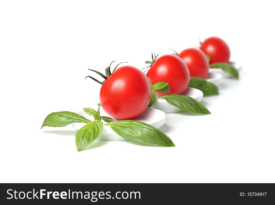 Four organic red tomato with basil leafs