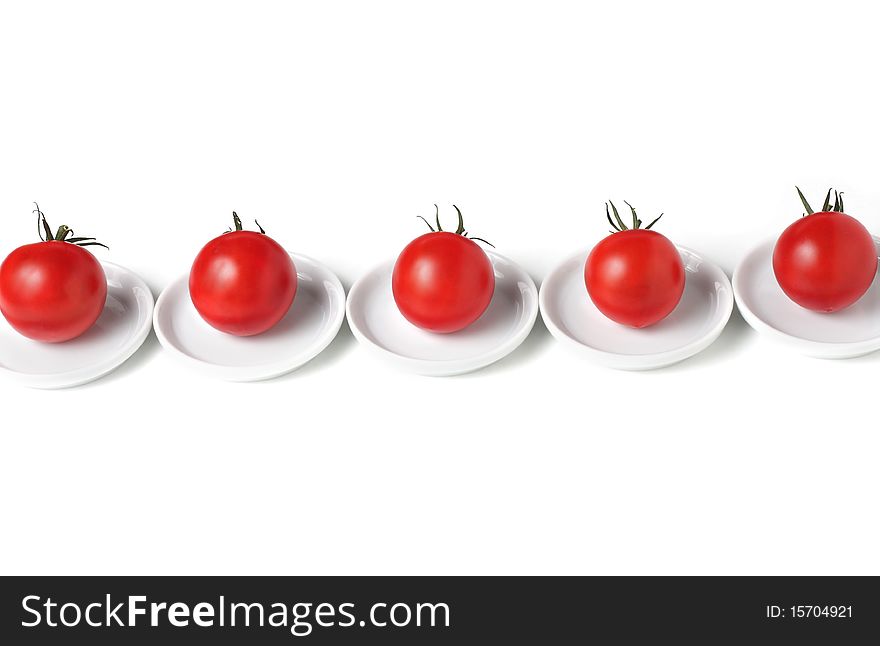 Five organic  tomatoes  on plates