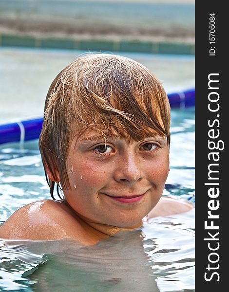 Boy enjoys swimming in an outdoor pool