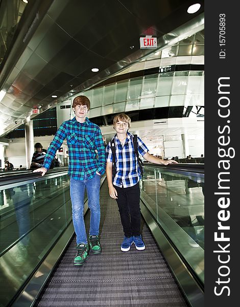 Young boys on a moving staircase inside the airport. Young boys on a moving staircase inside the airport