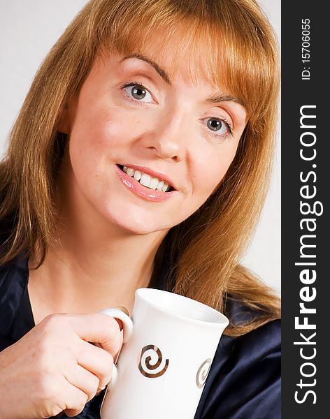 A vertical image of a pretty young woman in a cafe setting drinking coffee. A vertical image of a pretty young woman in a cafe setting drinking coffee