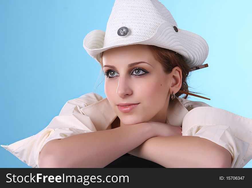 Girl on a blue background dreams. On her white hat. Girl on a blue background dreams. On her white hat.