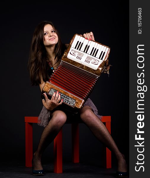 Girl with accordion on black bacground