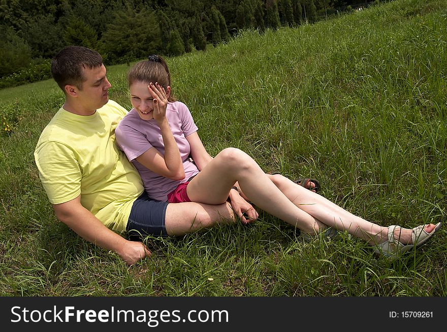 Young couple lying on the grass in the summer park