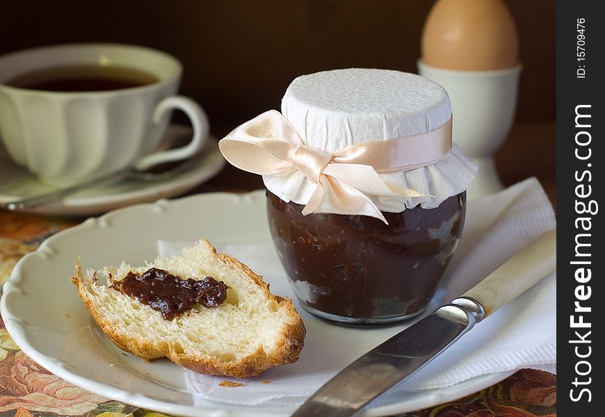 Croissant with chocolate cream, egg and coffee for breakfast