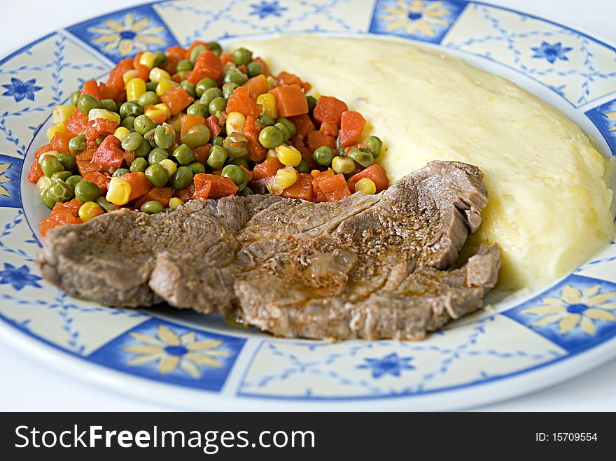 Meat with potato and mexican salad