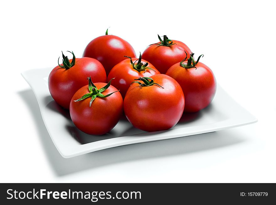 A shot of seven tomatoes on a plate