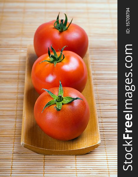 Ripe tomatoes on wooden background