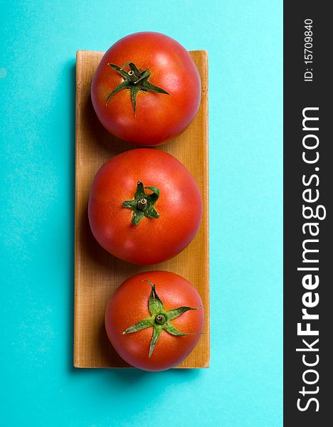 Ripe tomatoes on blue background
