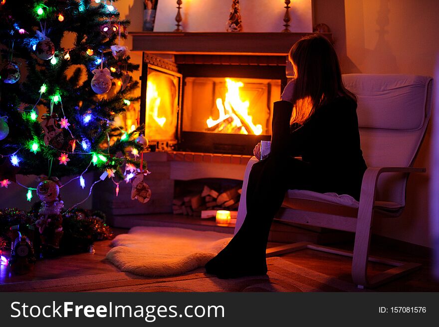 Woman relaxing by the fire place, winter weekends, cozy scene