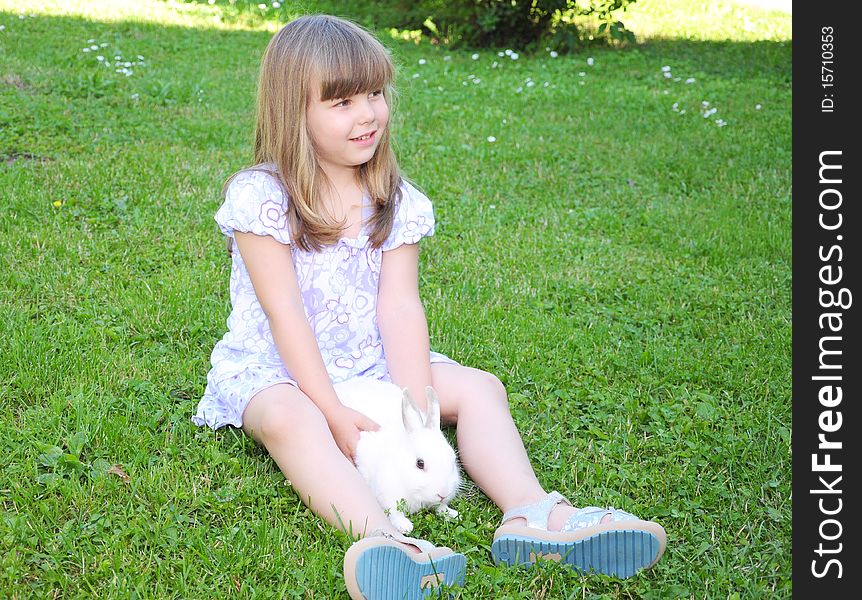 Girl with a rabbit in the grass. Girl with a rabbit in the grass