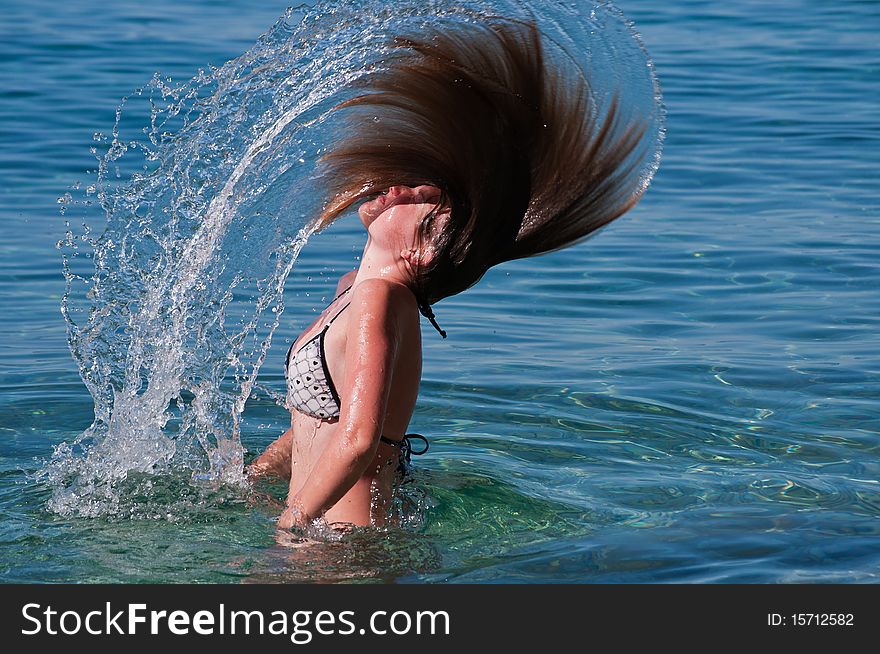 Girl is splashing water with her hair