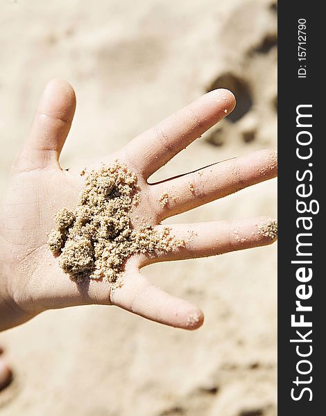 Child holding sand in the palm of their hand. Child holding sand in the palm of their hand