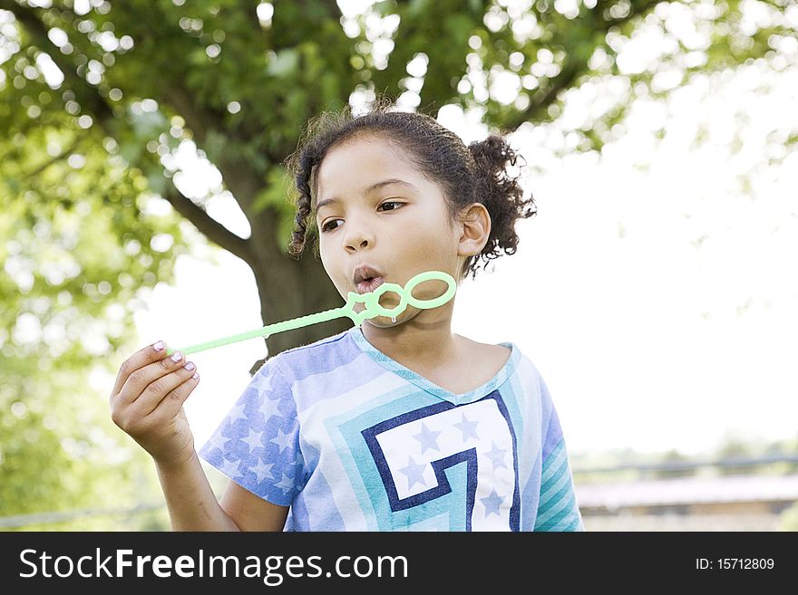 Little girl holding wand trying to blow bubbles. Little girl holding wand trying to blow bubbles
