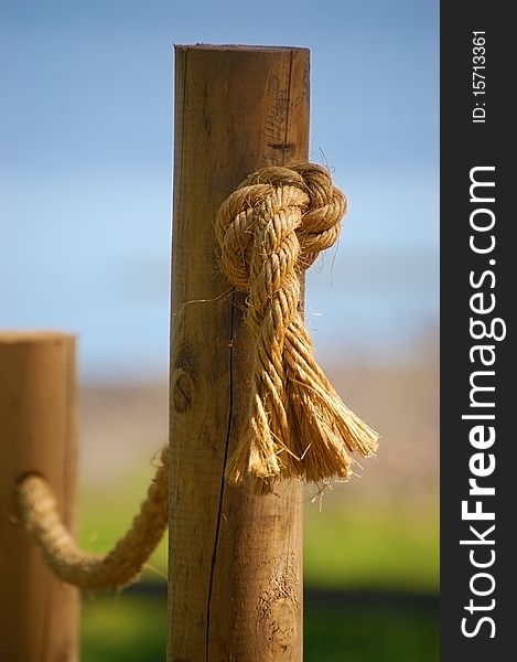 Detail of a rope handrail passing through round cedar posts. Detail of a rope handrail passing through round cedar posts