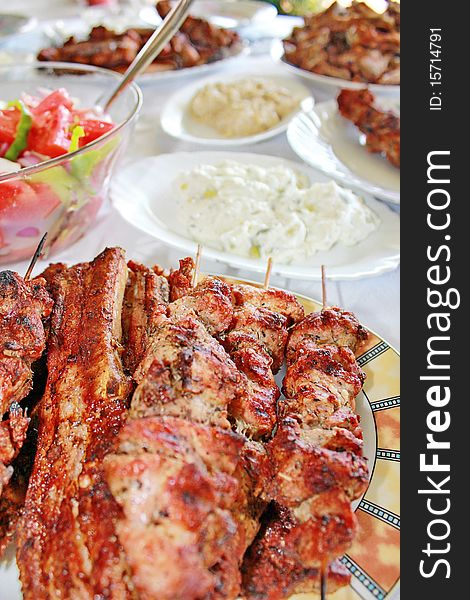 Variety traditional greek grilled meat souvlaki and chops and salads. Variety traditional greek grilled meat souvlaki and chops and salads