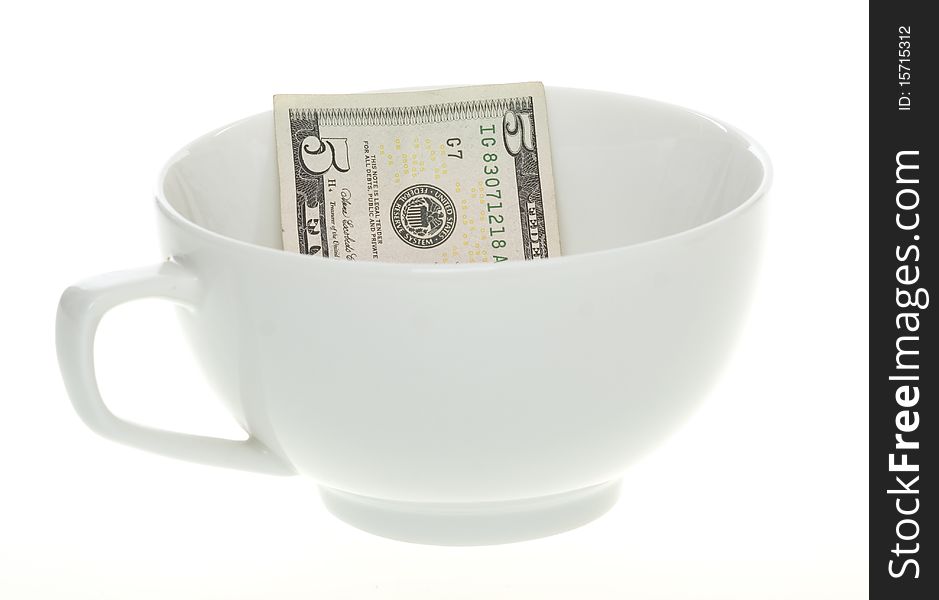 Conceptual: inflation: US Currency Five Dollar Bill in a White Coffee Mug or could be a soup cup, isolated on white background. Conceptual: inflation: US Currency Five Dollar Bill in a White Coffee Mug or could be a soup cup, isolated on white background.