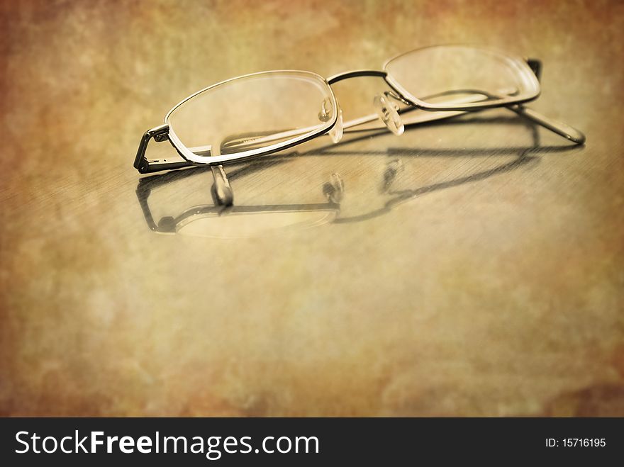 Closeup of Eyeglasses on top of a desk with reflection