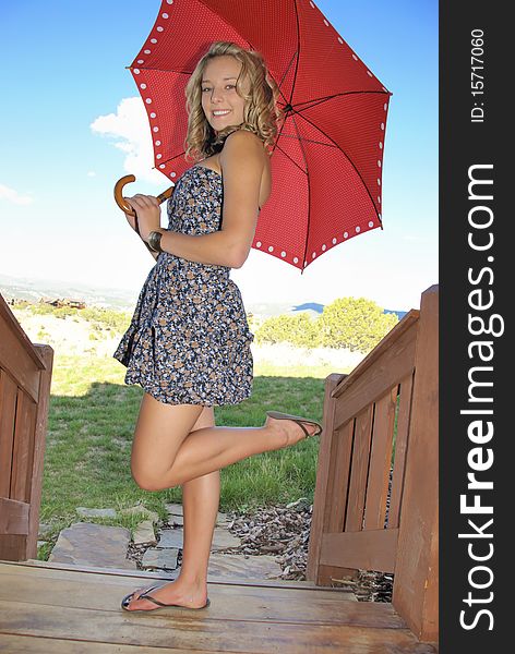 Teen on a deck with red umbrella